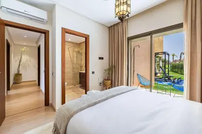 a bedroom with a large bed and a sliding glass door at Charme Marrakchi - Piscine, Jardin & Espace Sport in Marrakech