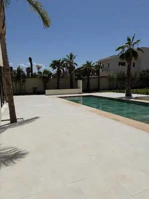 a swimming pool with palm trees in front of a building at Villa Enja - Swimming pool - 4 BR BA - Wi-Fi - Parking in Marrakech