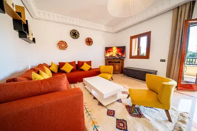 a living room with orange couches and yellow chairs at luxury gueliz in Marrakech