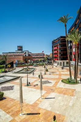 a park with palm trees in a city with buildings at luxury gueliz in Marrakech