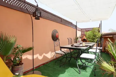 a patio with a table and chairs on a balcony at Naima's House in Marrakech
