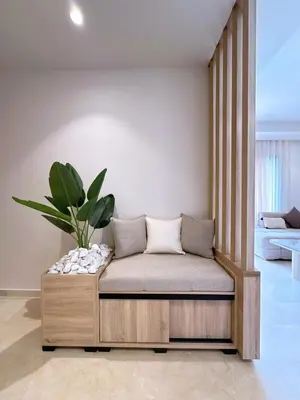 a couch in a living room with a plant at New! apptÉlégance ,Lumière et Confort avec piscine in Marrakech