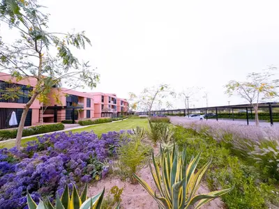 a garden with purple flowers in front of a building at New! apptÉlégance ,Lumière et Confort avec piscine in Marrakech