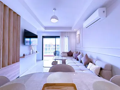 a living room with a couch and a table at New! apptÉlégance ,Lumière et Confort avec piscine in Marrakech