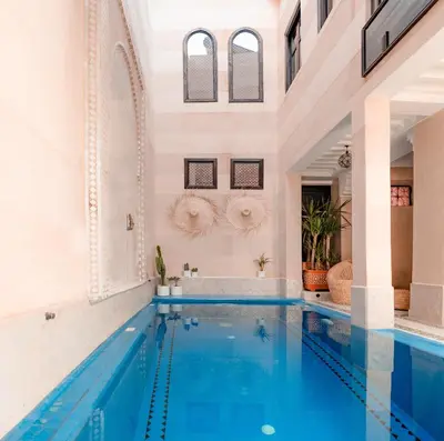 a swimming pool in a building with a tub and a sink at Riad Sahar Privé - Piscine Chauffée Sup - PDJ Inclus in Marrakech