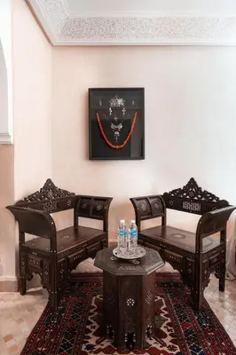 a room with two chairs and a table with water bottles at Riad Sahar Privé - Piscine Chauffée Sup - PDJ Inclus in Marrakech