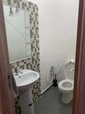 a bathroom with a sink and a toilet and a mirror at Spacious apartment 15 minutes from aéroport Marrakech reservation juste pour les familles est les couples mariés in Marrakech