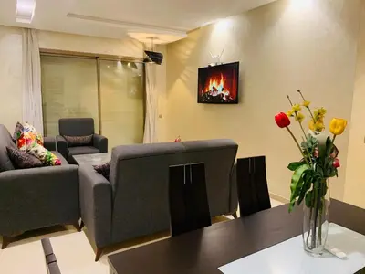 a living room with a couch and a table at Prestigious new 3-bedroom apartment with pool view in Marrakech