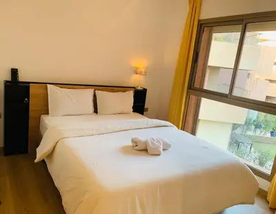 a bedroom with a bed with a towel on it at Prestigious new 3-bedroom apartment with pool view in Marrakech