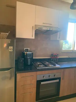 a kitchen with a stove top oven next to a refrigerator at Prestigious new 3-bedroom apartment with pool view in Marrakech