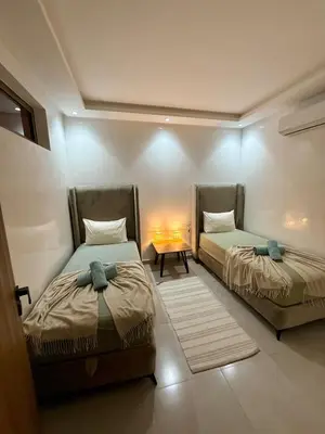 a room with two beds and a table in it at Séjour cosy à Marrakech centre in Marrakech