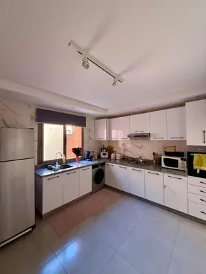 a large kitchen with white cabinets and appliances at Séjour cosy à Marrakech centre in Marrakech