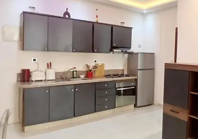 a kitchen with gray cabinets and a stainless steel refrigerator at Walili 1 in Marrakech