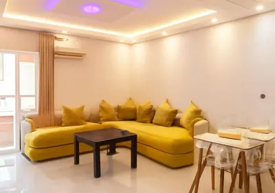 a yellow couch in a living room with a table at Walili 1 in Marrakech