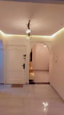 a hallway with a white door and a chandelier at شقة مفروشة in Marrakech