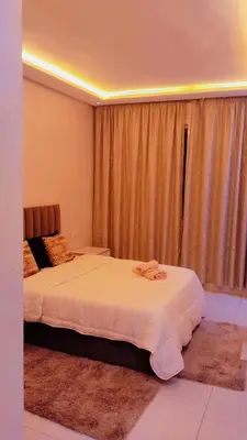 a bedroom with two beds and a window with curtains at شقة مفروشة in Marrakech