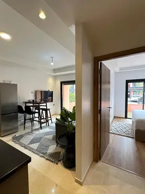 a room with a kitchen and a living room at Noria Golf Poolside Garden Flat in Marrakech