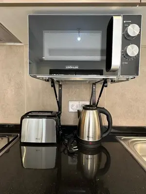 a kitchen counter with a microwave and a tea kettle at Noria Golf Poolside Garden Flat in Marrakech