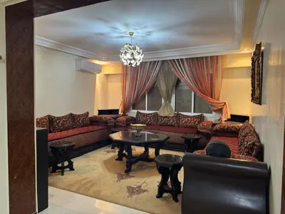 a living room with couches and a table at Appartement al acadimya in Marrakech