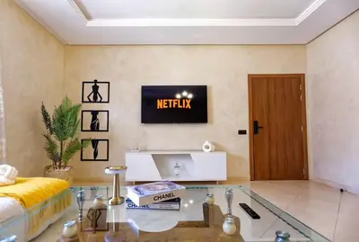 a living room with a glass table and a tv at Cozy Cove Marrakech in Marrakech