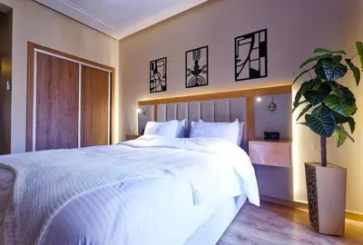 a bedroom with a large bed and a potted plant at Cozy Cove Marrakech in Marrakech