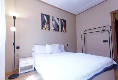 a bedroom with a white bed and two pictures on the wall at Cozy Cove Marrakech in Marrakech