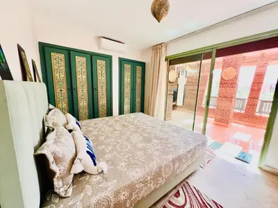 a bedroom with a bed and a large window at Apprt luxueux l'Hivernage au centre ville proche de la gare ,M avenu CR07 in Marrakech
