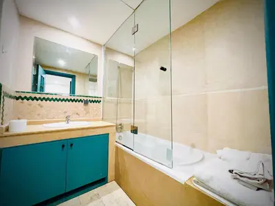 a bathroom with a tub and a sink and a shower at Apprt luxueux l'Hivernage au centre ville proche de la gare ,M avenu CR07 in Marrakech