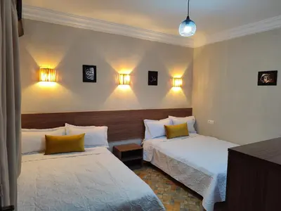 a hotel room with two beds and lights on the wall at Apartment 5 minutes from Marrakech Airport in Marrakech