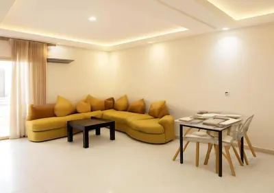 a living room with a yellow couch and a table at Appart Walili in Marrakech