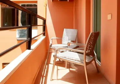 two chairs sitting on a balcony next to a window at Appart Walili in Marrakech