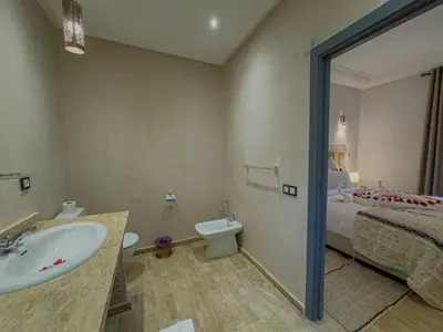 a bathroom with a sink and a toilet and a bed at Riad Tonaroz Gold in Marrakech