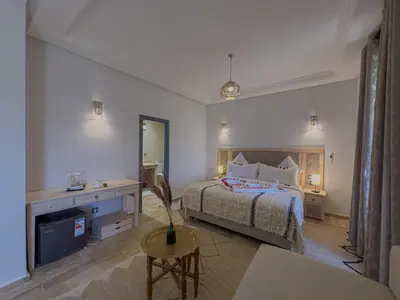 a bedroom with a bed and a living room at Riad Tonaroz Gold in Marrakech