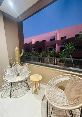 a balcony with two chairs and a table and chairs at 3 bedroom apartment in Marrakech