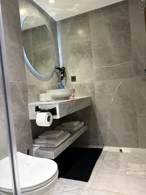 a bathroom with a sink and a toilet and a mirror at Magnifique loft haut de gamme avec grande terrasse zen et fontaine murale situé en plein centre-ville de Marrakech dans le cœur du quartier Gueliz à proximité des rues commerçantes et animées du Carré Eden et du Plaza Dépôt de garantie obligatoire in Marrakech