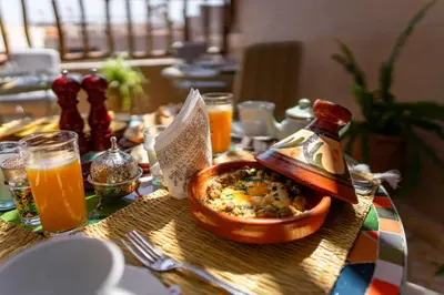a table with a bowl of food and orange juice at Riad 26 in Marrakech
