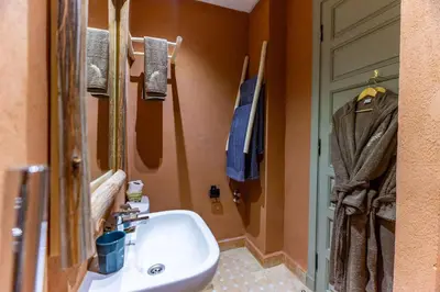 a bathroom with a white sink and a door at Riad 26 in Marrakech