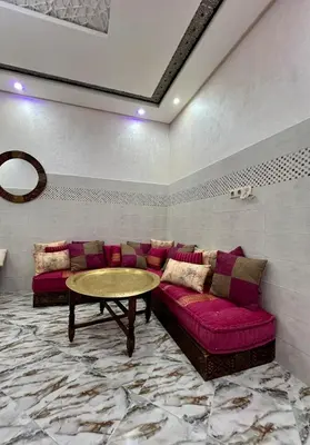 a living room with a couch and a table at Appartement spacieux de luxe familial in Marrakech