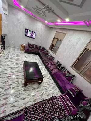 a room with purple couches and a flat screen tv at Appartement spacieux de luxe familial in Marrakech