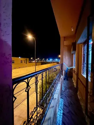 a person standing on a balcony at night at Appartement spacieux de luxe familial in Marrakech
