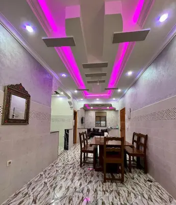 a dining room with purple lights on the ceiling at Appartement spacieux de luxe familial in Marrakech