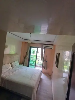a bedroom with a bed and a large window at Résidence les amis 2 chambres appartement familial in Marrakech