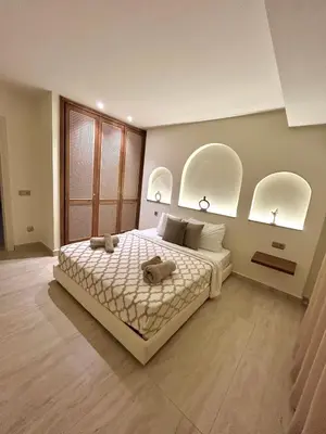 a bedroom with a large bed with three arched windows at Eden Vibes GUELIZ in Marrakech