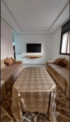a living room with two couches and a flat screen tv at Kech Amal Apartment in Marrakech