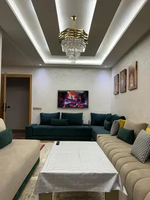a living room with blue couches and a chandelier at Marrakech Luxe & confort Appartement in Marrakech