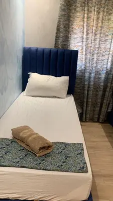 a bed with a blue headboard and a pillow on it at Marrakech Luxe & confort Appartement in Marrakech