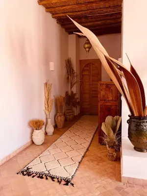 a room with potted plants and a hallway with a door at Dar Tal, Marrakech in Douar Oulad Ali