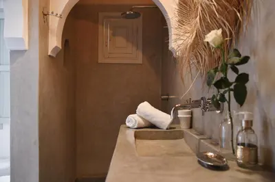 a bathroom with a sink with a vase of flowers at Riad Nūr in Marrakech