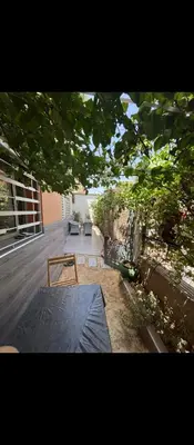 a view of a patio with a table and a bench at Appartement calme chez Nawal in Marrakech