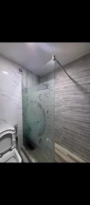 a bathroom with a shower with a glass wall at Appartement calme chez Nawal in Marrakech